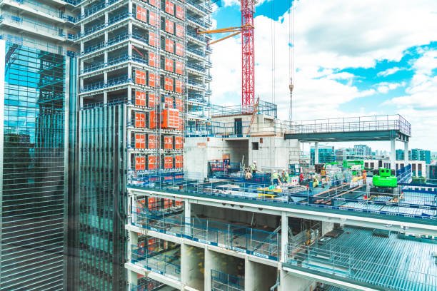 View at construction site with unfinished residential buildings against blue sky, London