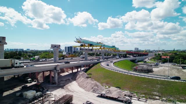 Rising aerial showcasing launching Gantry machinery over Dolphin Expressway, Miami, Florida, USA